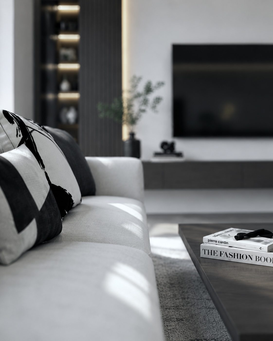 Close view of a pale sofa with black and white cushions in a living room with lit dark joinery